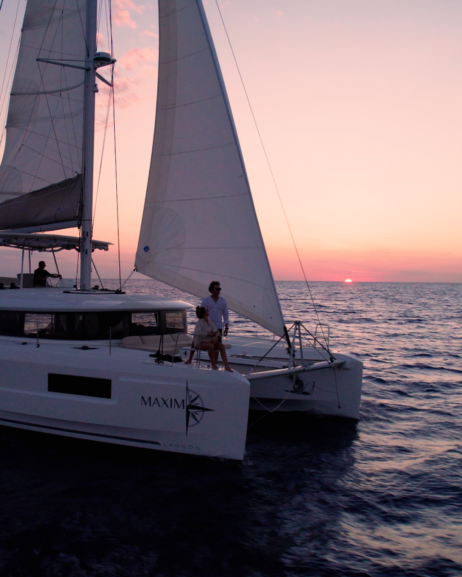 Sunset over the sea from the deck of a catamaran